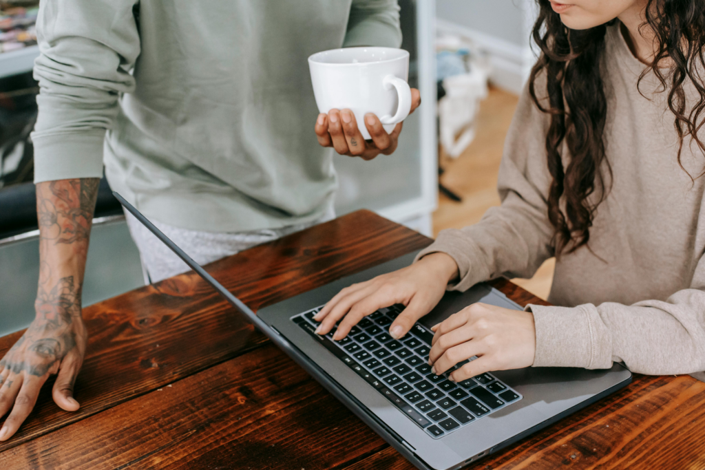 A woman and man talking over a computer about website maintenance
