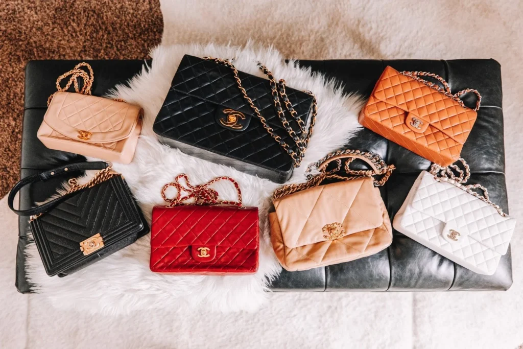 some designer bags on a fur and leather bench