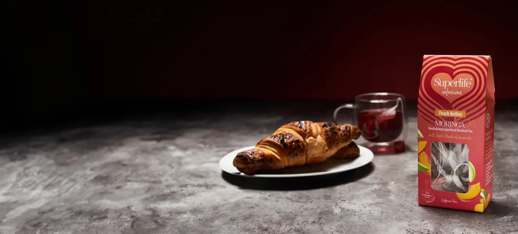 a photo of a superlife infusions tea box and a croissant