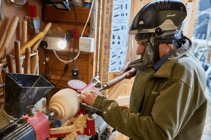 a man turning wood